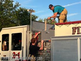 Captain Fogle and Jr. Firefighter Colin loading the hoses on Engine 2-1.